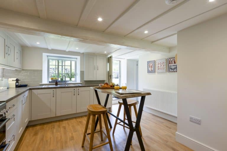 Modern kitchen with white cabinets and wooden breakfast bar in Yorkshire Escapes.