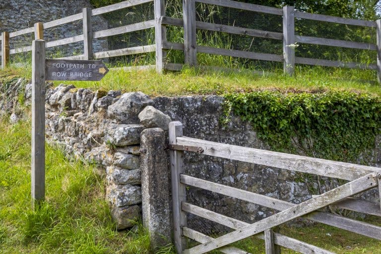 Footpath to Rievaulx Abbey via a rustic wooden gate and stone wall.