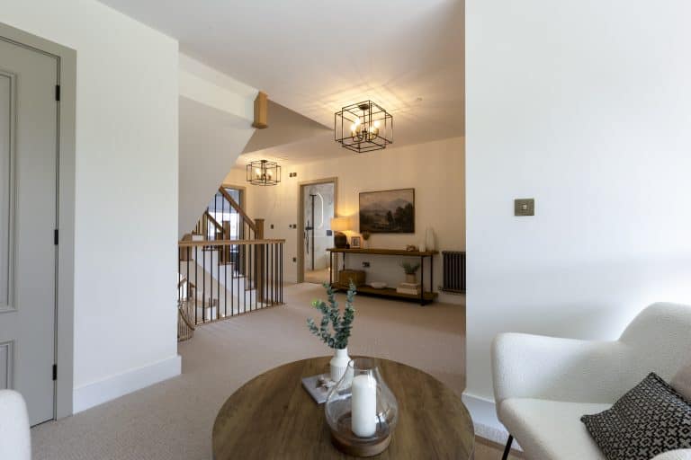 Bright, modern living room with staircase and elegant lighting fixtures.