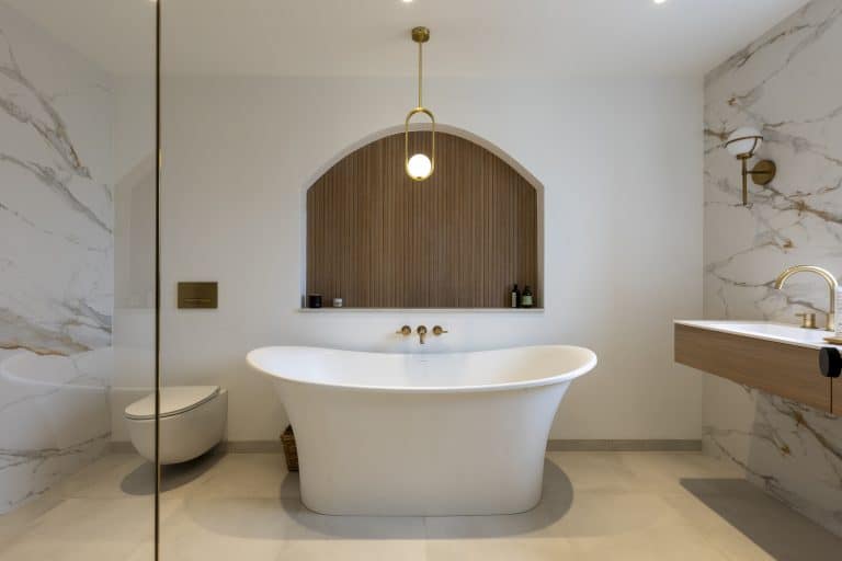 Modern bathroom with freestanding bathtub and marble walls near York.