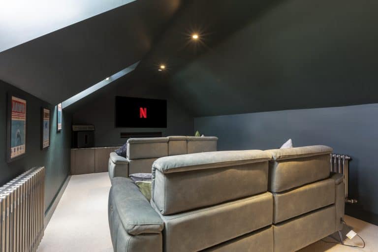 Cozy attic lounge with sofas and a Netflix screen in Yorkshire Escapes property.