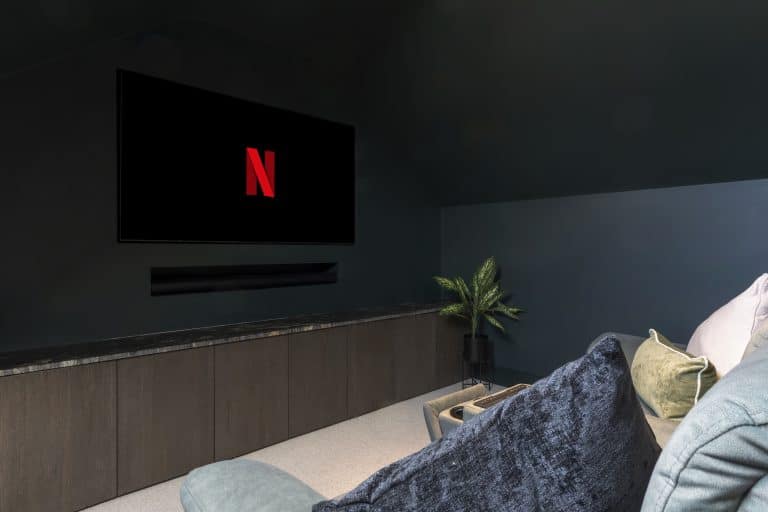 Modern living room with a wall-mounted Netflix screen and cosy seating area.