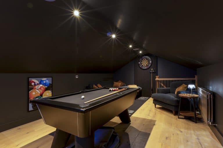 Indoor game room with pool table, dartboard, and seating area in Yorkshire Escapes.